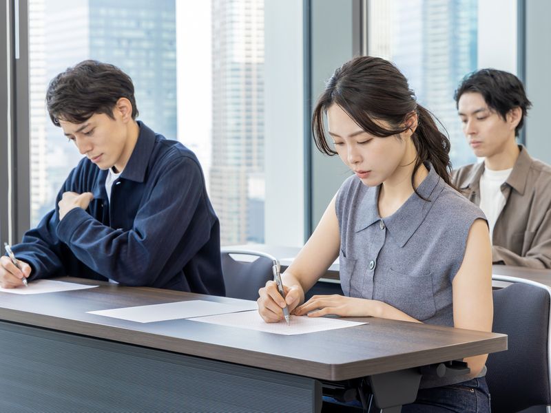 打ち合わせの場でメモを取る参加者